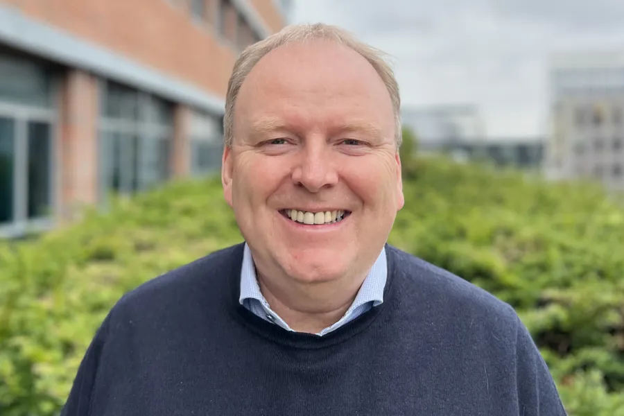 En mann som smiler til kameraet